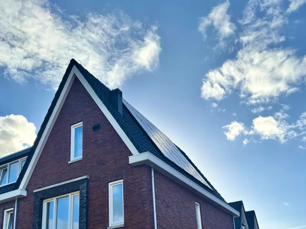 Woning met zonnepanelen op het dak die stroom opwekken uit zonlicht